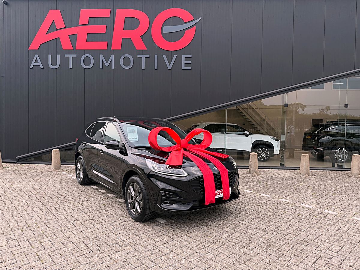 Recent afgeleverde zwarte Ford Kuga met rode strik voor de showroom van Aero Automotive